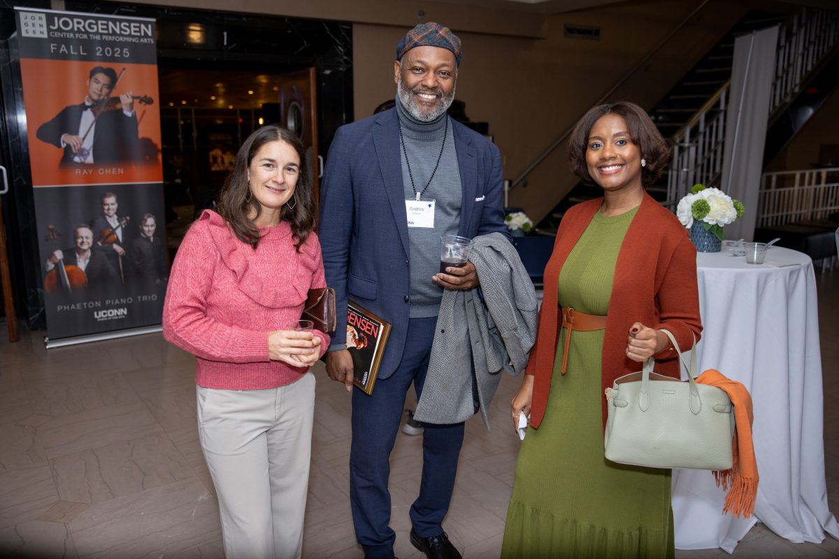 Two ladies and a gentleman posing for a picture.