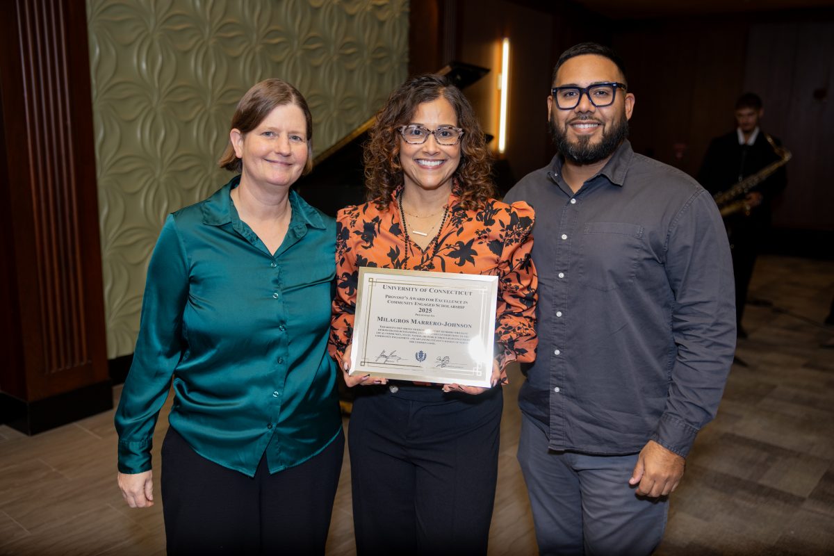 Two ladies and a gentleman posing for a picture.