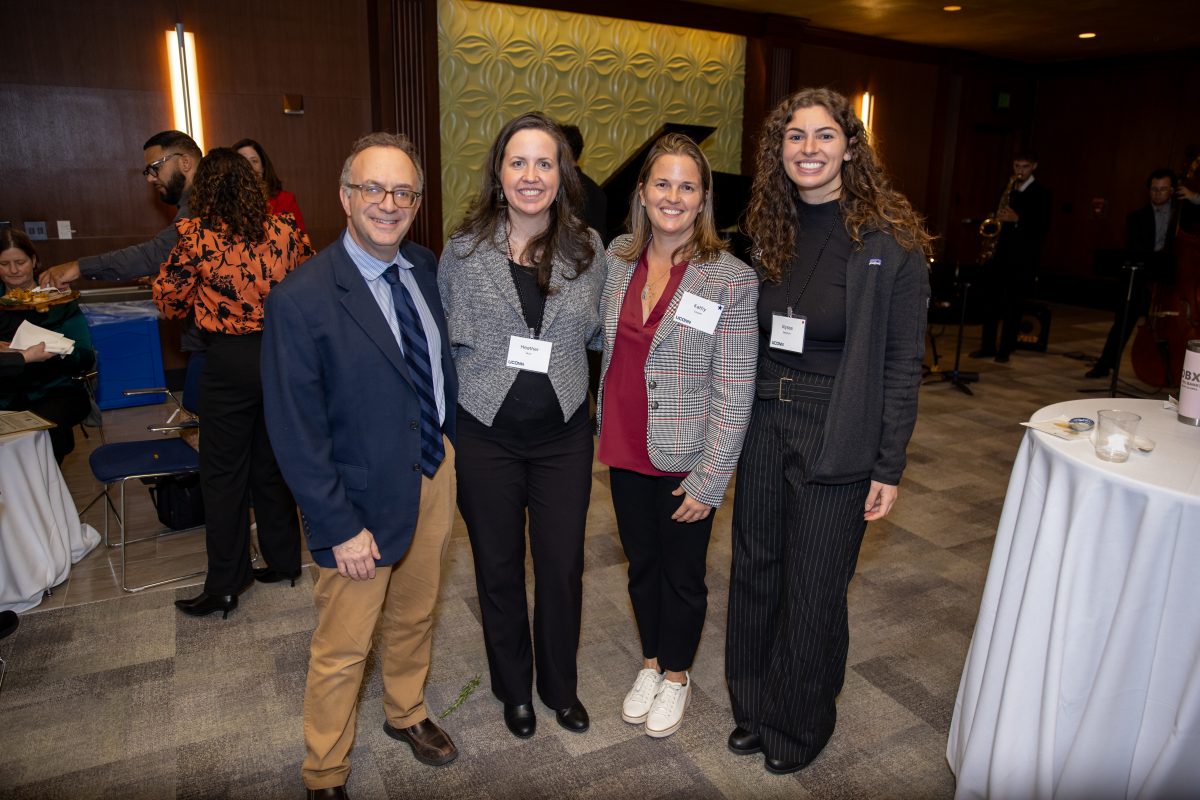 Three ladies and a gentleman posing for a picture.
