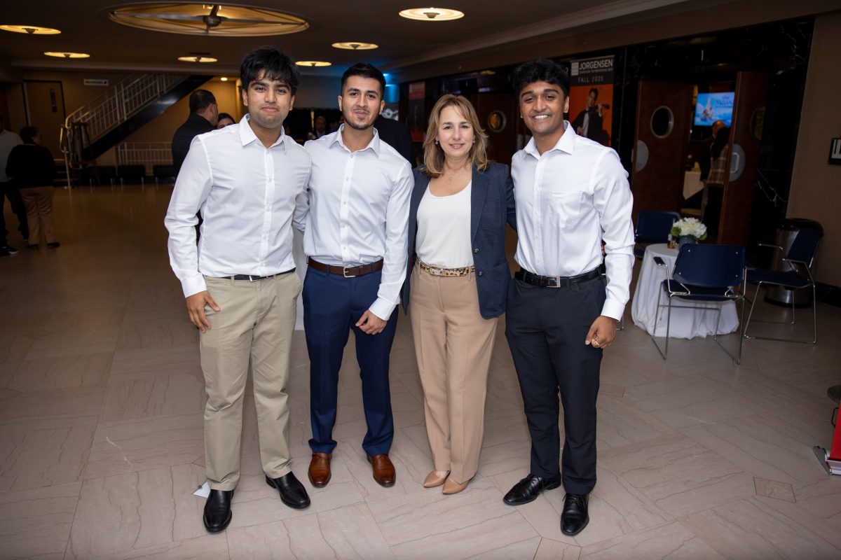 Three gentleman with a lady in the center. 